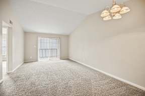 A room with a carpeted floor and a ceiling fan with five lights.