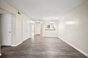A long hallway with wood floors and white walls.