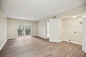 A room with wooden flooring and white walls.