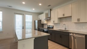 a kitchen with white cabinets and a granite counter top