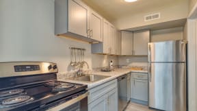 a kitchen with white cabinets and stainless steel appliances