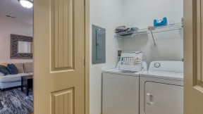 a laundry room with a washer and dryer and a door to a room