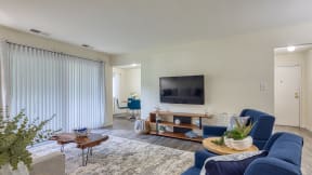a living room with blue furniture and a tv on the wall