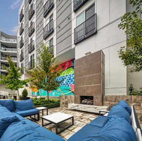 A patio with a fireplace and a colorful mural on the wall at Mosaic Summit Pointe in Chesapeake, Virginia, 23320
