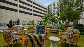 A patio with chairs and tables is surrounded by buildings at Mosaic Summit Pointe in Virginia, 23320