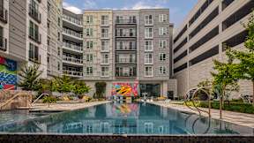 A large pool in front of a building with a mural on the wall at Mosaic Summit Pointe in Chesapeake, Virginia
