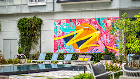 A pool with chairs and a colorful mural on the wall at Mosaic Summit Pointe in Chesapeake, VA, 23320