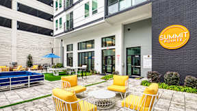A yellow chair is in front of a Summit Pointe sign at Evening at Mosaic Summit Pointe VA, 23320