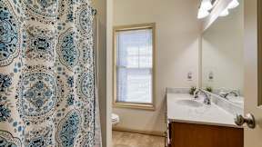 A bathroom with a patterned shower curtain and a white sink.