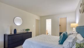 a bedroom with a bed and a dresser and a mirror