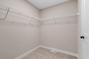 A room with a carpeted floor and a white door.