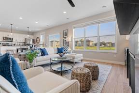 A modern living room with a white sofa, a glass coffee table, and a flat-screen TV.
