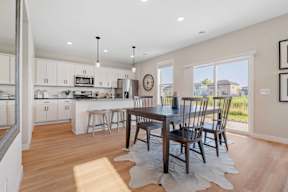 A kitchen with a table and chairs in the middle of the room.