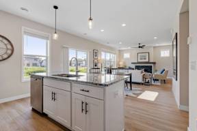 A modern kitchen with a large island and pendant lights.