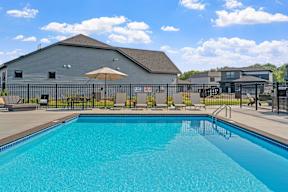 A large swimming pool in front of a grey building.