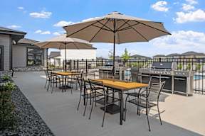 A patio with a table and chairs under an umbrella.