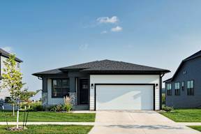 A modern house with a white garage door and a black roof.