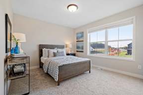 A bedroom with a large bed and a window overlooking a street.
