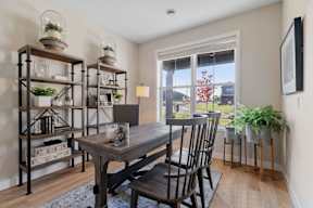 A dining room with a wooden table and chairs.
