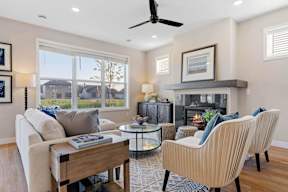 A living room with a fireplace, two chairs, and a coffee table.