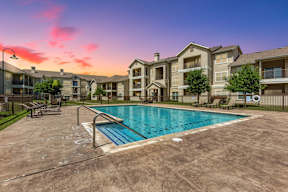 A large swimming pool in front of apartment buildings.