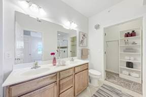 A bathroom with a white sink and a white toilet.