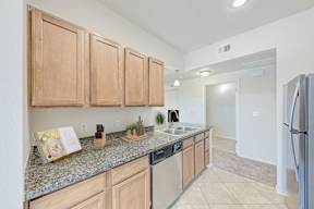 A kitchen with wooden cabinets and granite countertops.