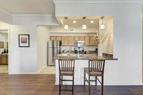 A kitchen with a table and two chairs.