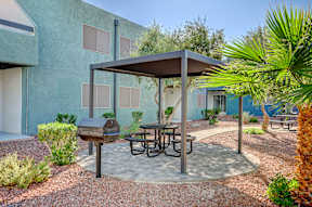A patio with a table and chairs under a canopy.