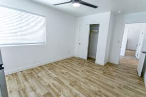 A room with a ceiling fan and wooden flooring.