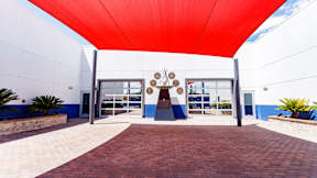 A building with a red canopy and a blue and white facade.
