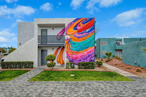 A colorful mural on a building in a residential area.