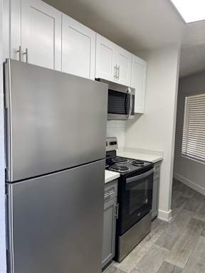 A modern kitchen with a stainless steel refrigerator and oven.