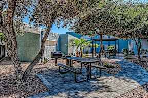 A picnic table is surrounded by trees in a courtyard.