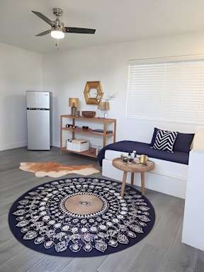 A living room with a couch, a rug, and a ceiling fan.