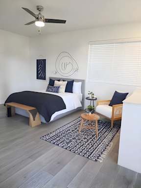 A bedroom with a bed, a bench, and a rug.