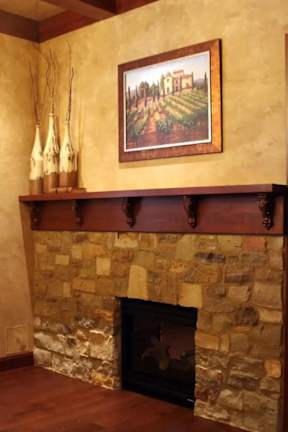 A fireplace with a painting above it and candles on the mantle.