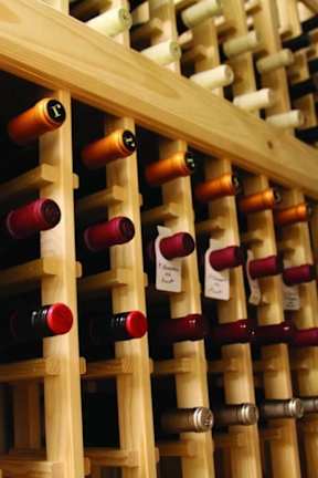 A wine rack with bottles of wine in various colors.