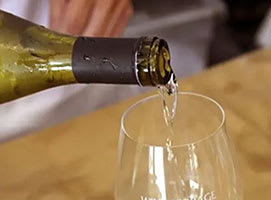 A bottle of champagne is being poured into a glass.