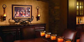 A room with a painting on the wall and candles on the table.