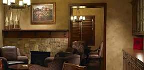 A living room with a fireplace and a painting on the wall.