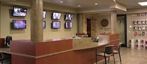 A reception area with a desk and multiple TVs on the wall.