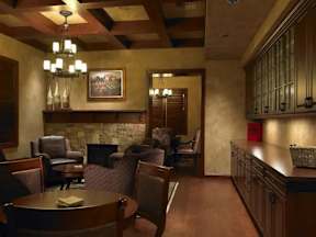 A room with a stone fireplace and wooden floors.
