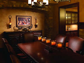 A restaurant with a long table and candles on it.