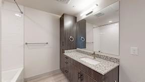 A bathroom with a sink, mirror, and cabinets at Railside at Wadsworth Station, Lakewood, 80214