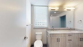 A bathroom with a toilet, sink, and mirror at Railside at Wadsworth Station, Lakewood, 80214