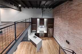 A room with a brick wall and a balcony.