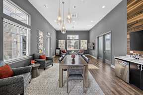A modern living room with a grey couch, a coffee table, and a large window.