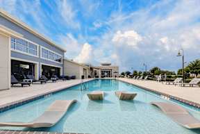 A large swimming pool with a slide and sun loungers.