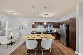 A modern kitchen with a dining table set for two.
